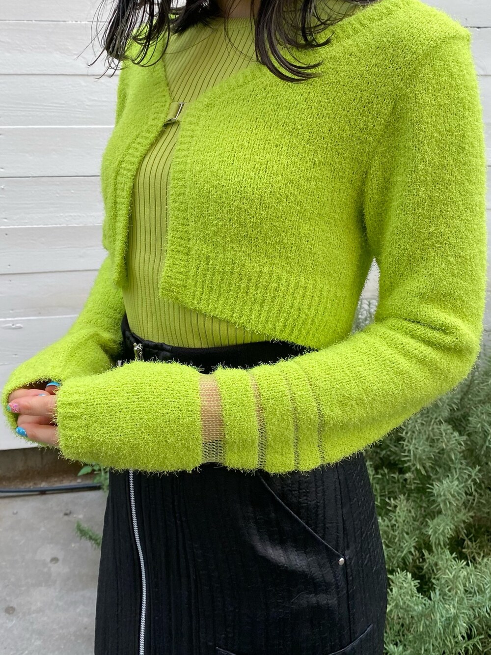 グリーン系のニット/セーター、ブラック系のスカートを着用したレディースの冬コーディネートの6枚目の写真