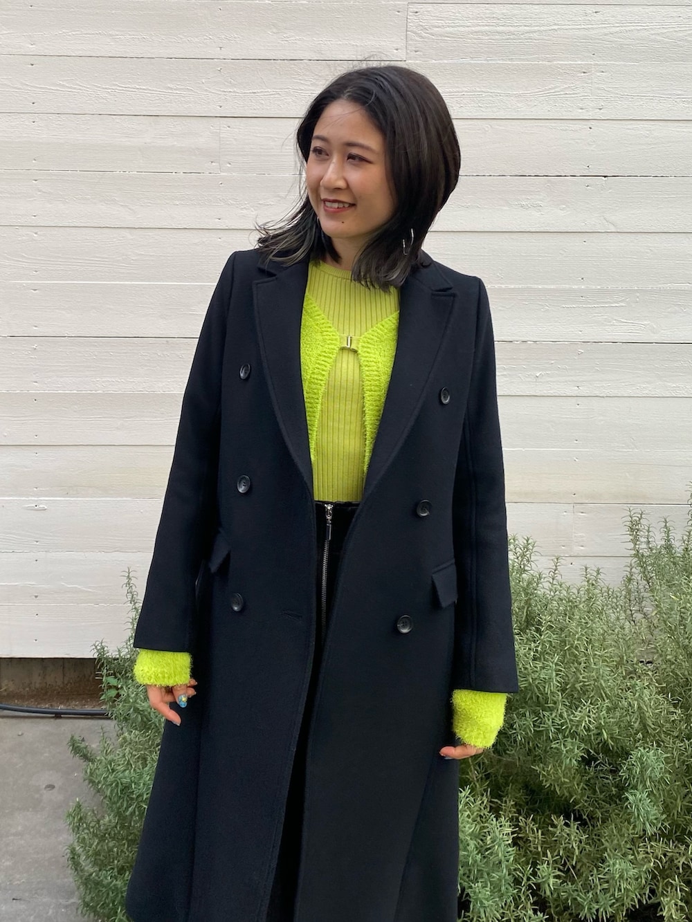 ブラック系のチェスターコートを着用したレディースの冬コーディネートの4枚目の写真