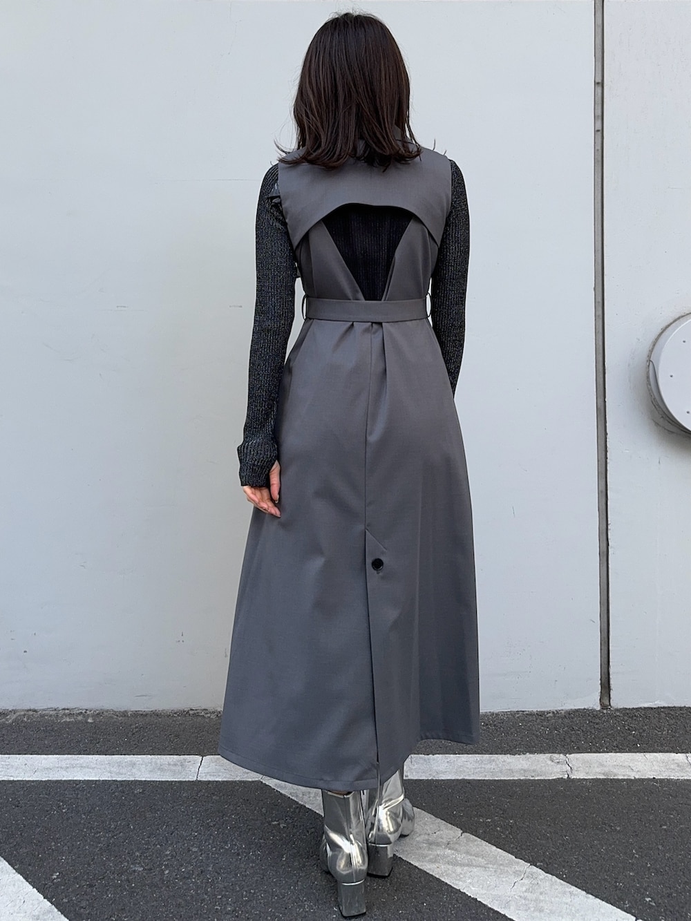 ブラック系のニット/セーター、グレー系のジャンパースカートを着用したレディースの冬コーディネートの3枚目の写真