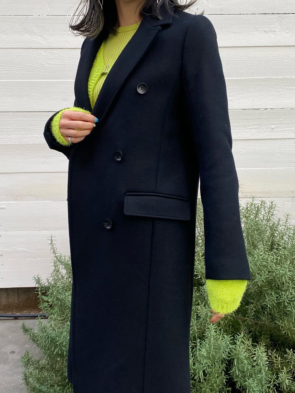 ブラック系のチェスターコートを着用したレディースの冬コーディネートの6枚目の写真