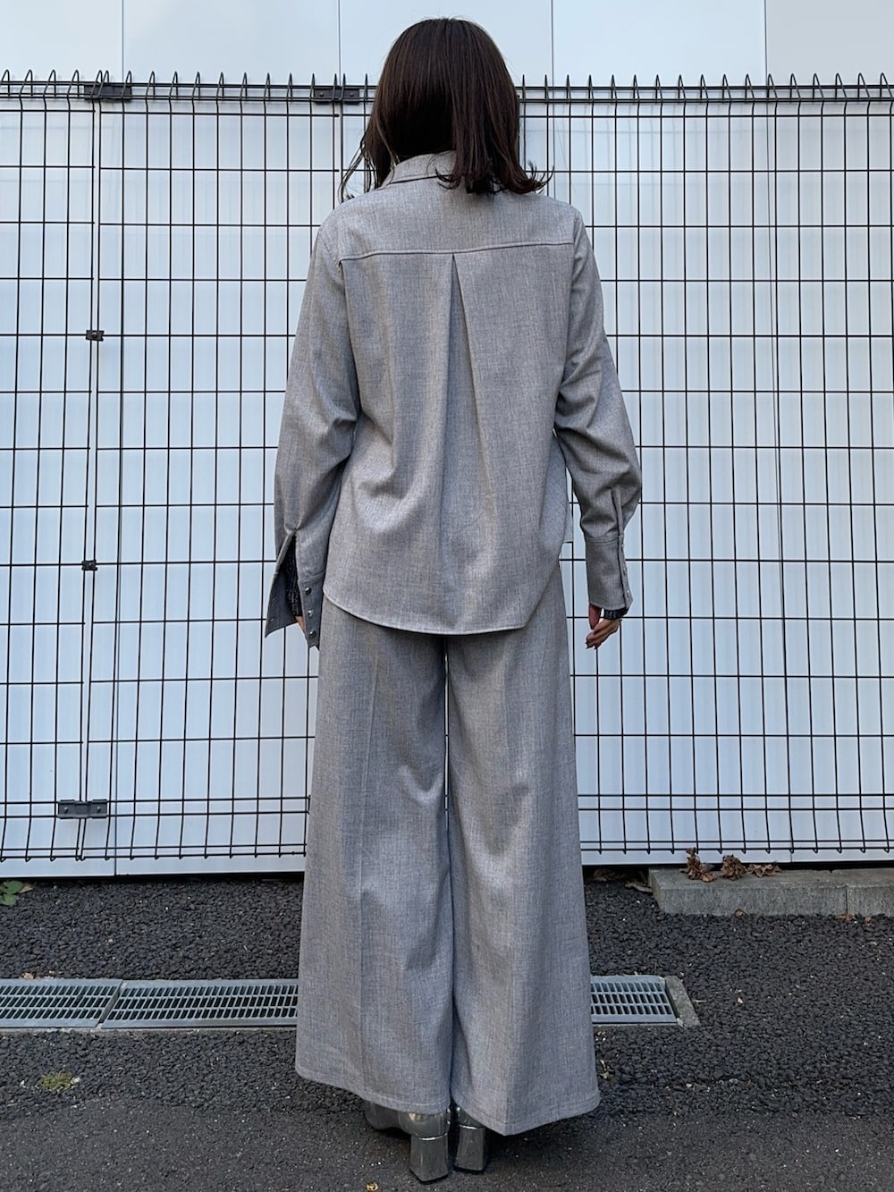 グレー系のシャツ/ブラウス、グレー系のスラックスを着用したレディースの冬コーディネートの3枚目の写真