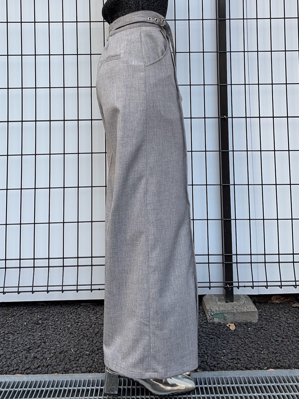 ブラック系のニット/セーター、グレー系のスラックスを着用したレディースの冬コーディネートの7枚目の写真