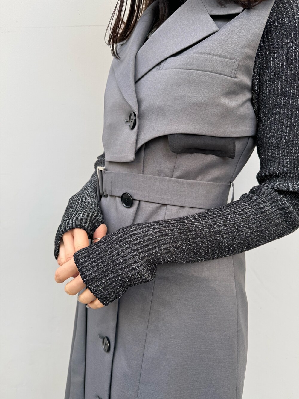 ブラック系のニット/セーター、グレー系のジャンパースカートを着用したレディースの冬コーディネートの8枚目の写真