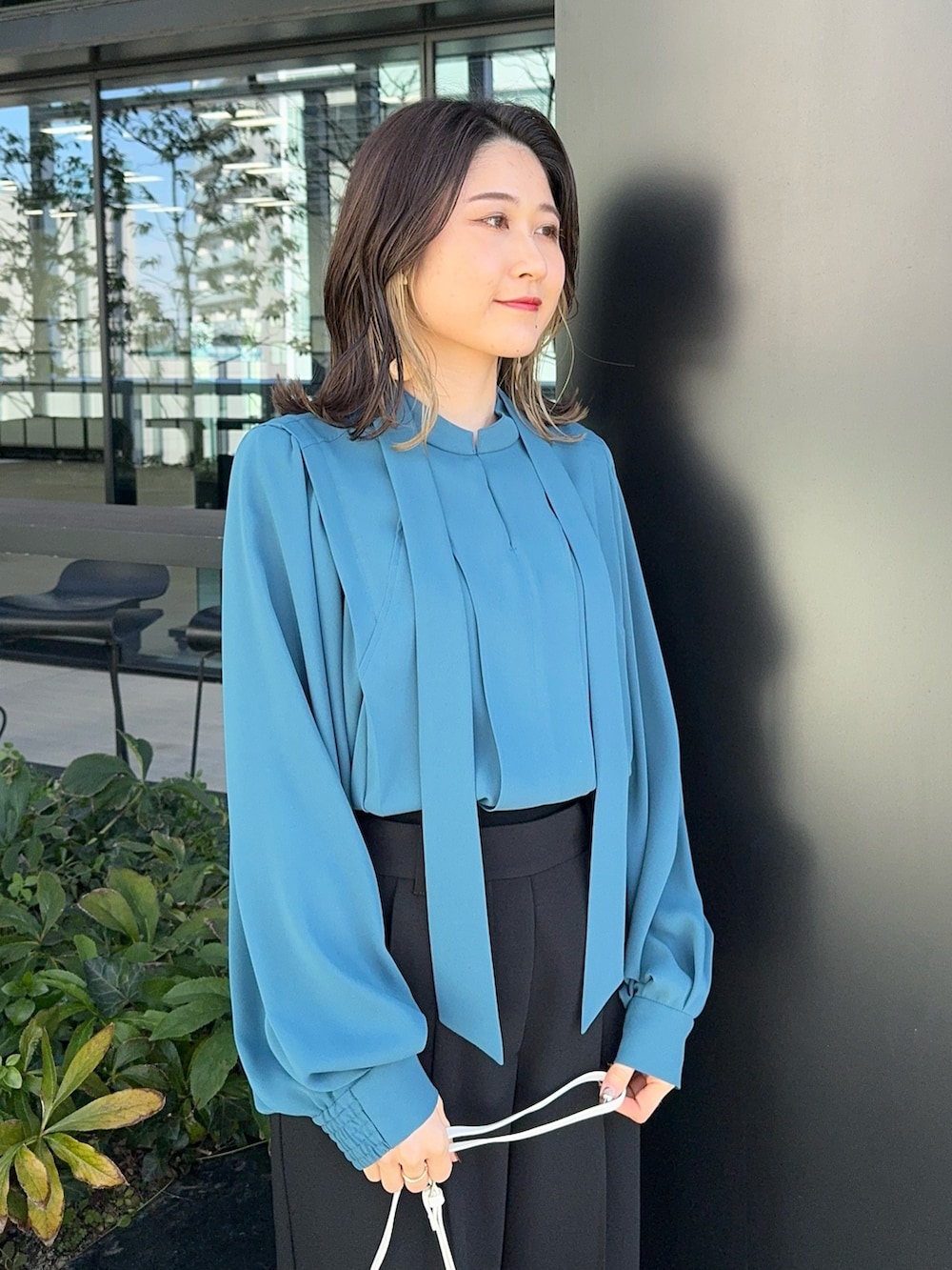 ブラック系のその他パンツ、ホワイト系のショルダーバッグを着用したレディースの冬コーディネートの8枚目の写真