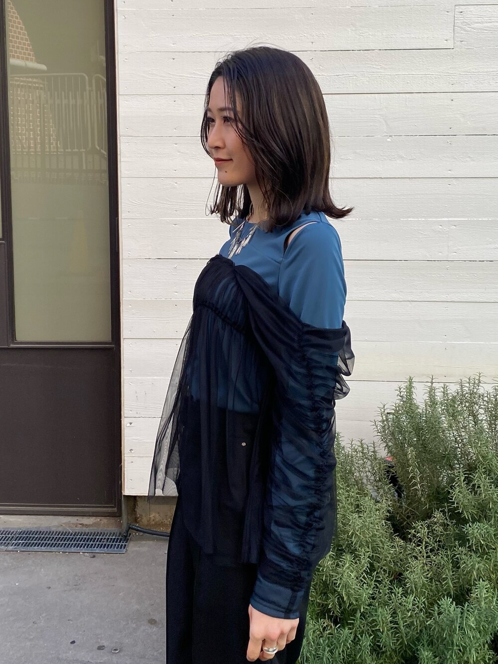 グリーン系のTシャツ/カットソー、ブラック系のスラックスを着用したレディースの冬コーディネートの6枚目の写真