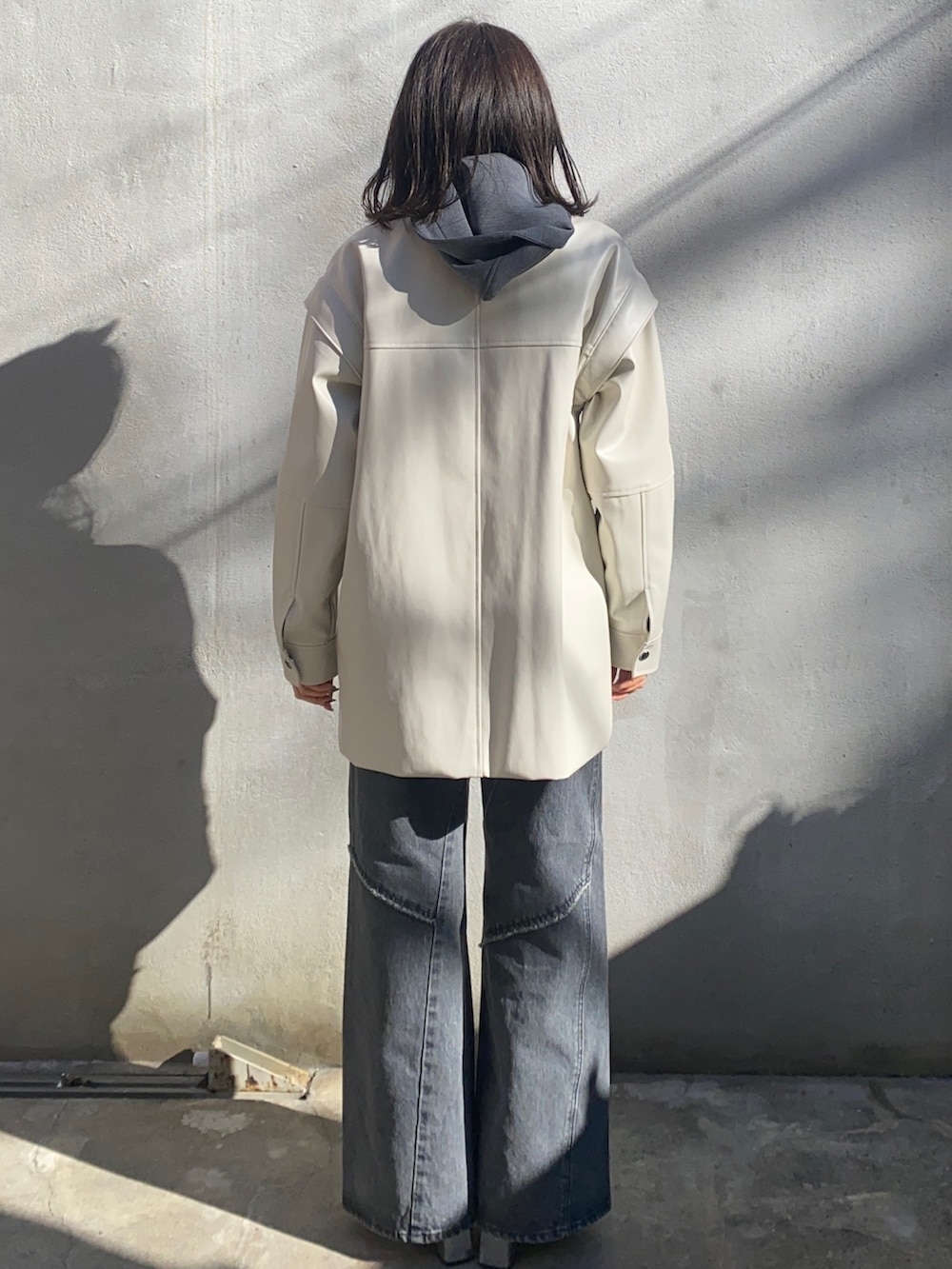 ホワイト系のブルゾン、ホワイト系のTシャツ/カットソー、グレー系のパーカーを着用したレディースの冬コーディネートの3枚目の写真