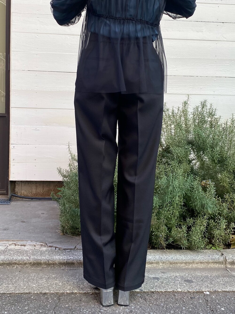 グリーン系のTシャツ/カットソー、ブラック系のスラックスを着用したレディースの冬コーディネートの10枚目の写真