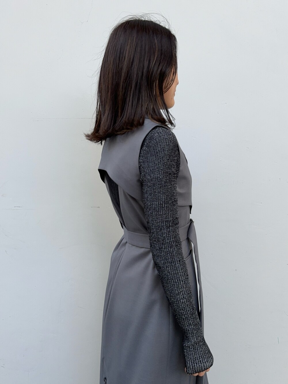 ブラック系のニット/セーター、グレー系のジャンパースカートを着用したレディースの冬コーディネートの6枚目の写真