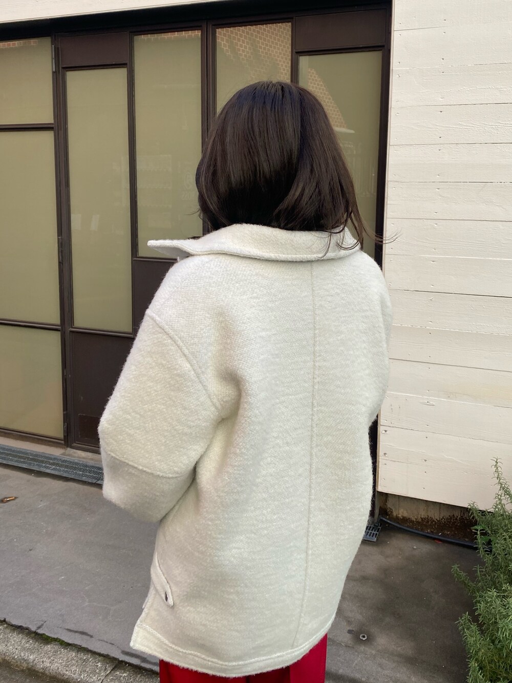 レッド系のその他パンツ、ホワイト系のニット/セーター、イエロー系のニット/セーターを着用したレディースの冬コーディネートの6枚目の写真