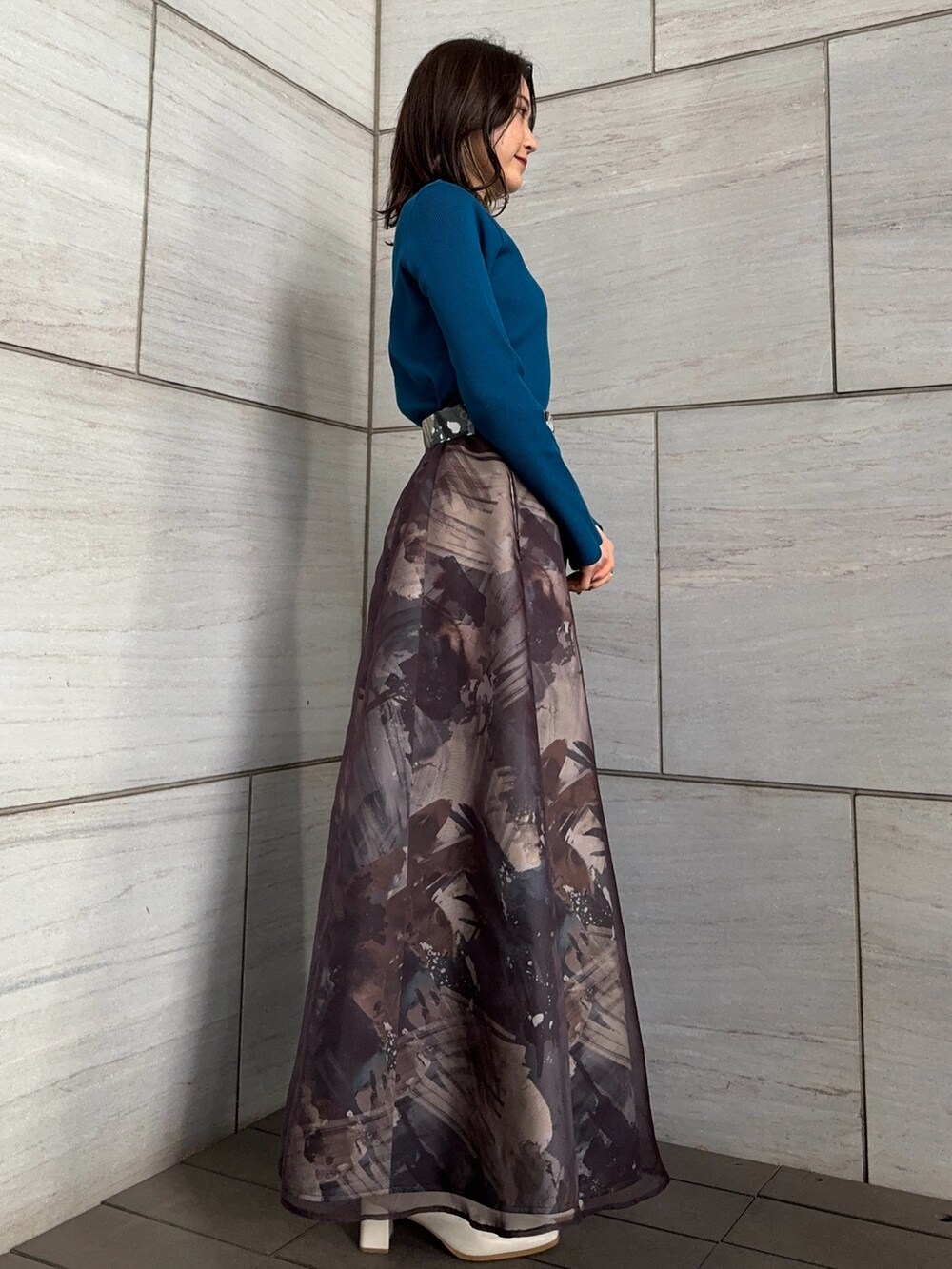 ブルー系のニット/セーター、グレー系のスカートを着用したレディースの冬コーディネートの2枚目の写真