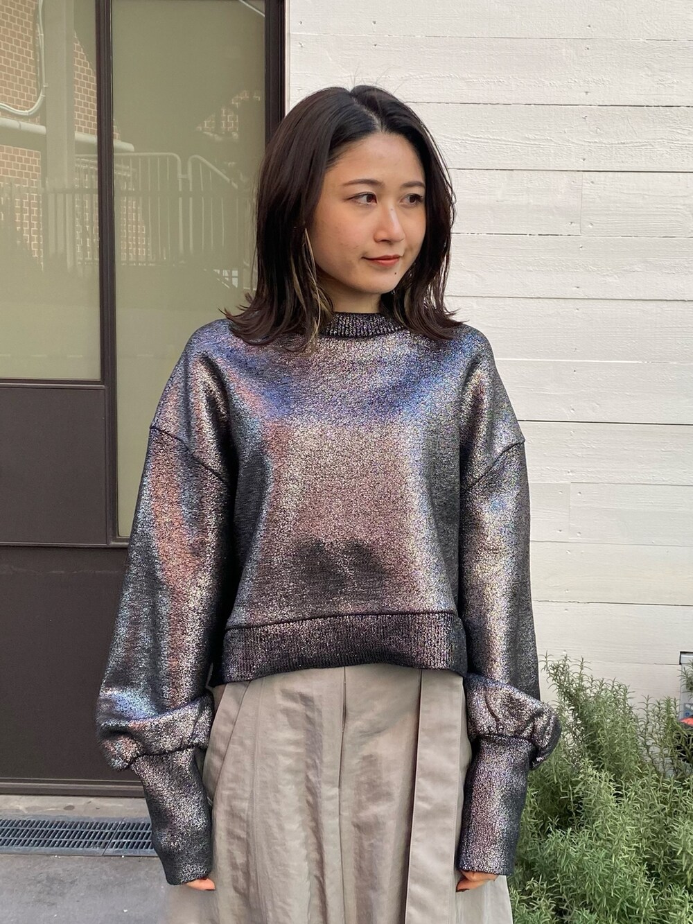 グレー系のスカート、シルバー系のニット/セーターを着用したレディースの冬コーディネートの6枚目の写真