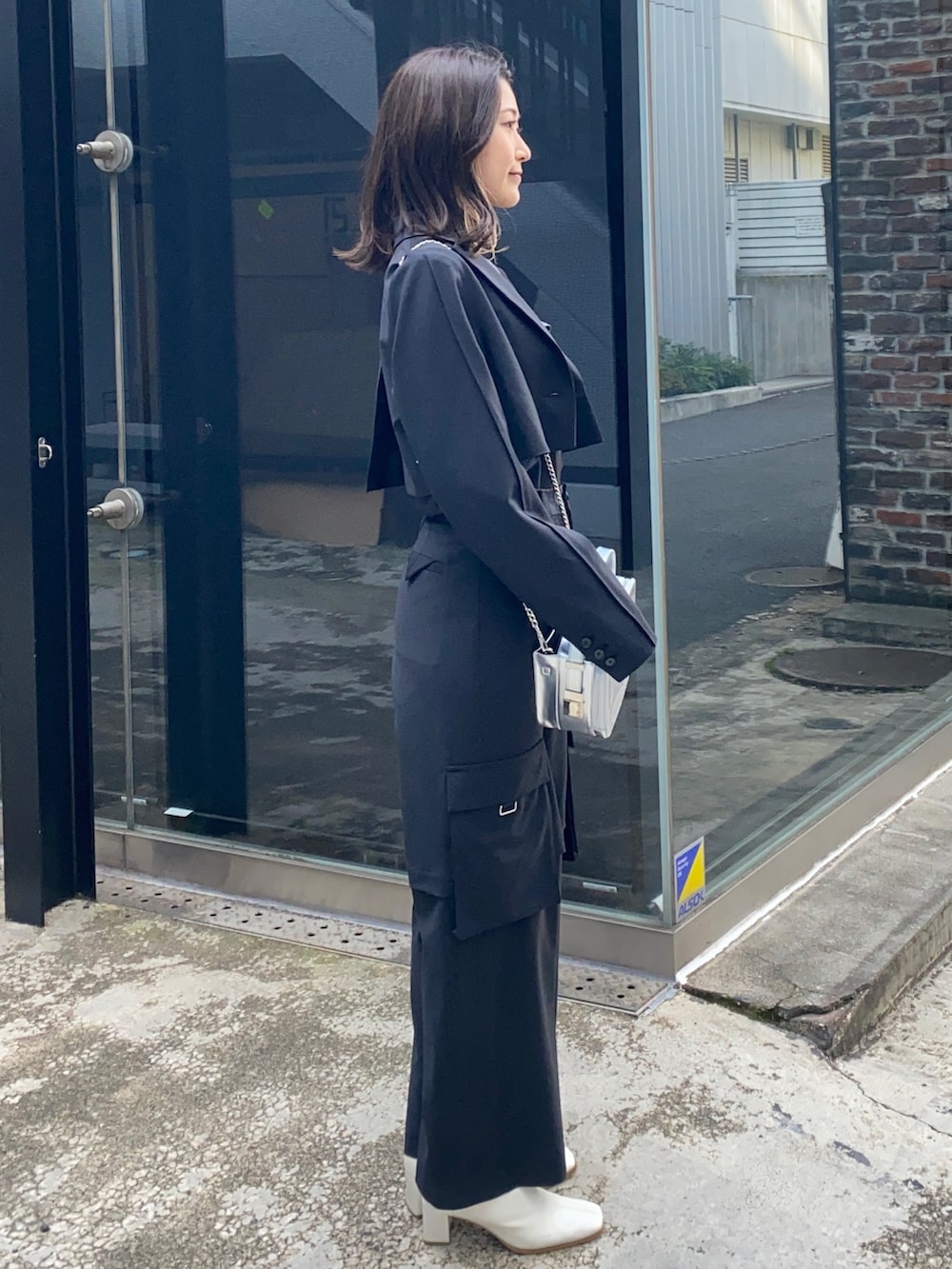 シルバー系のショルダーバッグ、ブラック系のシャツ/ブラウス、ブラック系のテーラードジャケットを着用したレディースの冬コーディネートの2枚目の写真