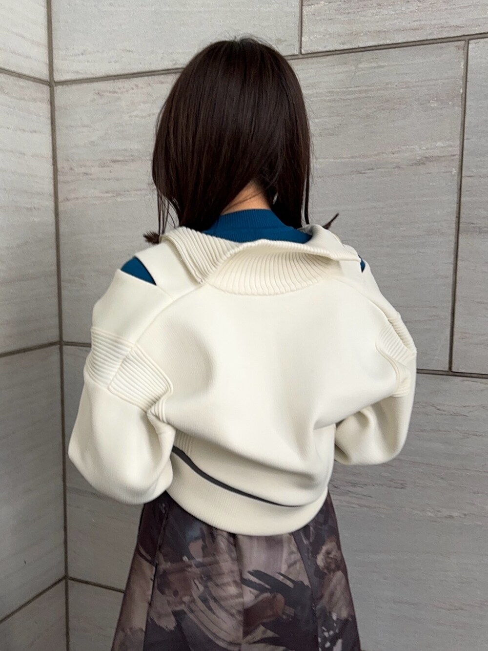 ブルー系のニット/セーター、ホワイト系のニット/セーター、グレー系のスカートを着用したレディースの冬コーディネートの6枚目の写真