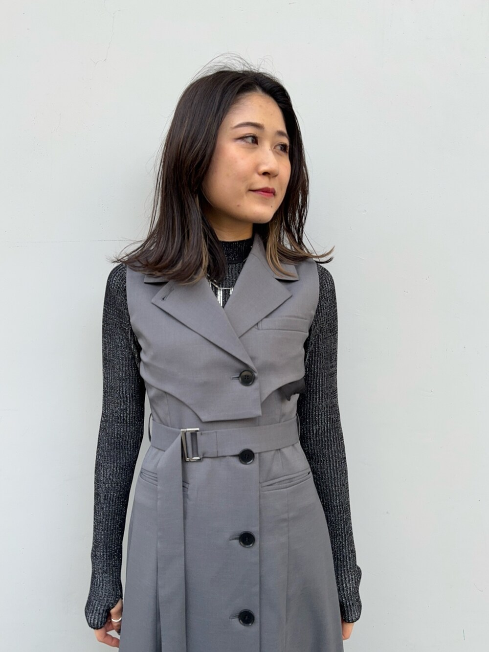 ブラック系のニット/セーター、グレー系のジャンパースカートを着用したレディースの冬コーディネートの5枚目の写真