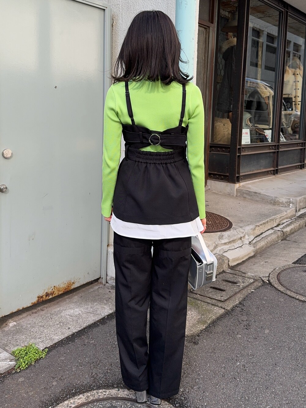 グリーン系のニット/セーター、ブラック系のベスト、ブラック系のその他パンツを着用したレディースの冬コーディネートの3枚目の写真