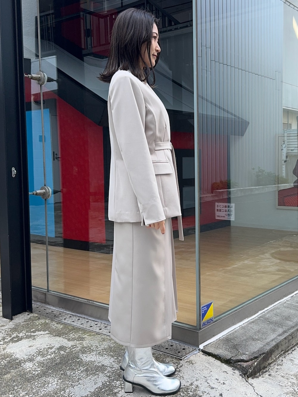 ベージュ系のスカート、ベージュ系のセットアップを着用したレディースの冬コーディネートの2枚目の写真