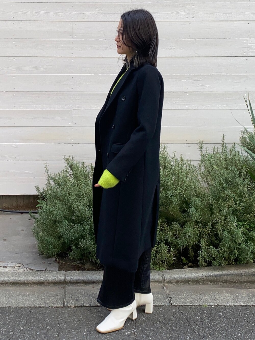 ブラック系のチェスターコートを着用したレディースの冬コーディネートの2枚目の写真