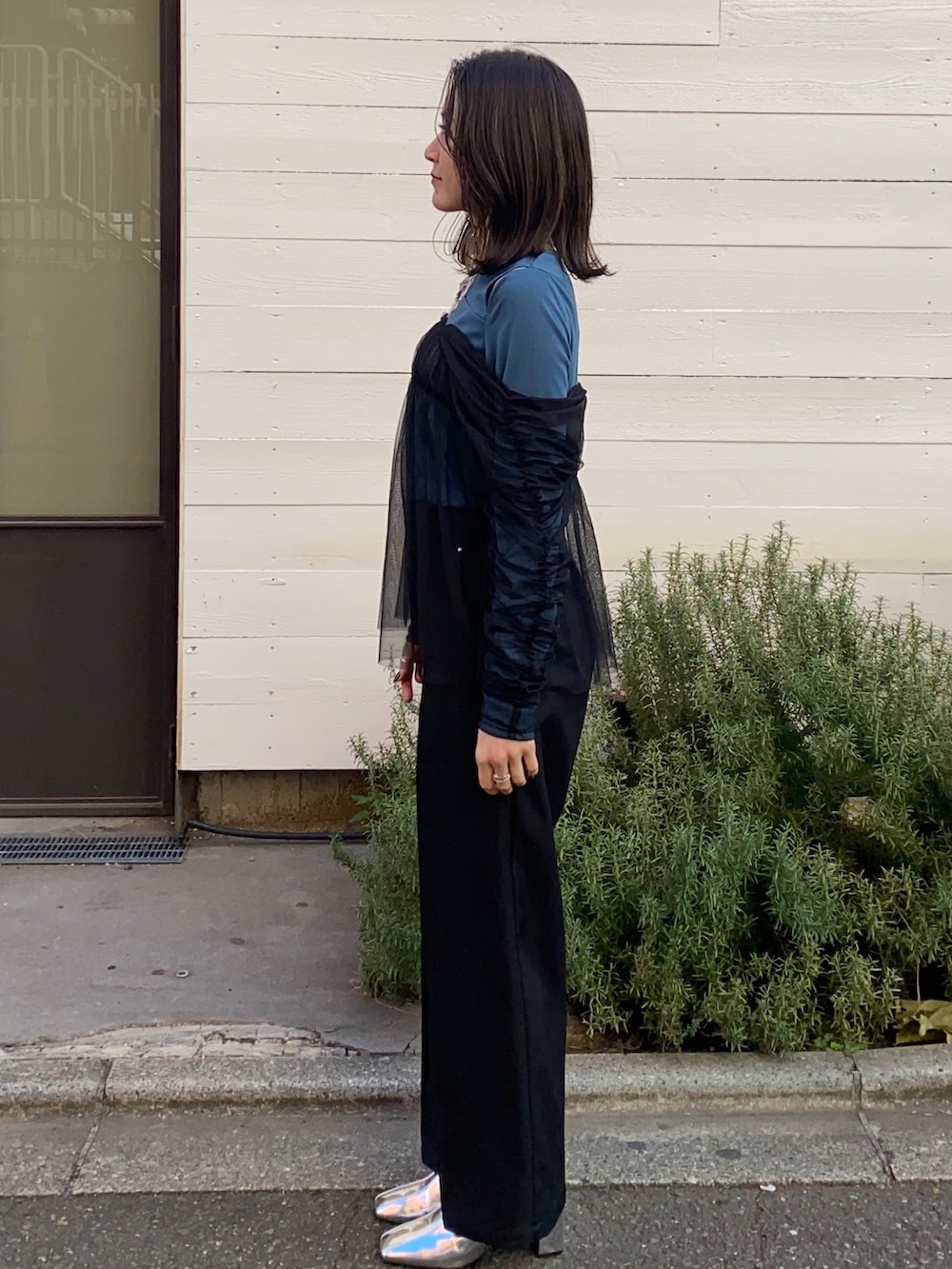 グリーン系のTシャツ/カットソー、ブラック系のスラックスを着用したレディースの冬コーディネートの4枚目の写真