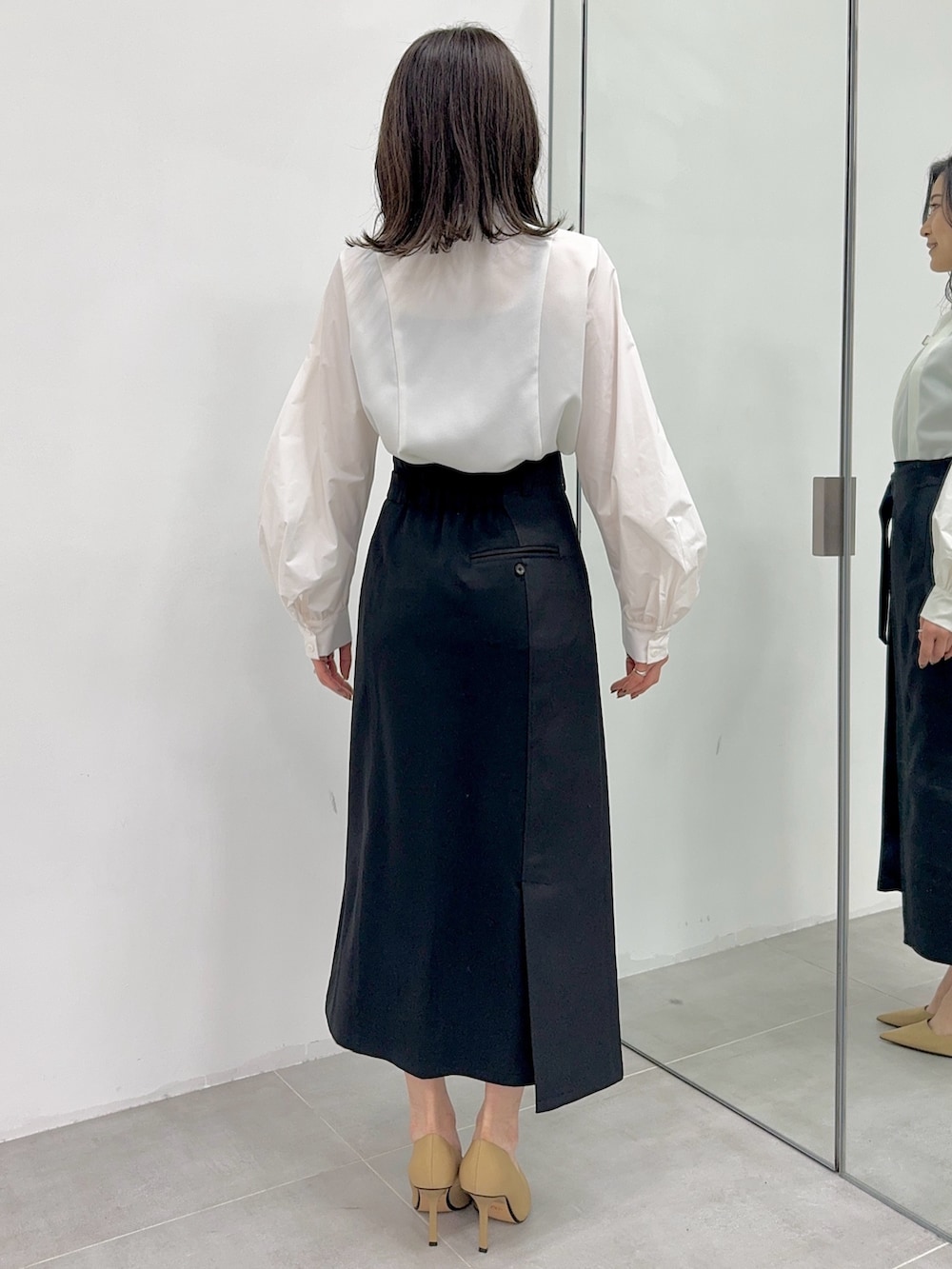 ホワイト系のシャツ/ブラウス、ブラック系のスカートを着用したレディースの冬コーディネートの3枚目の写真
