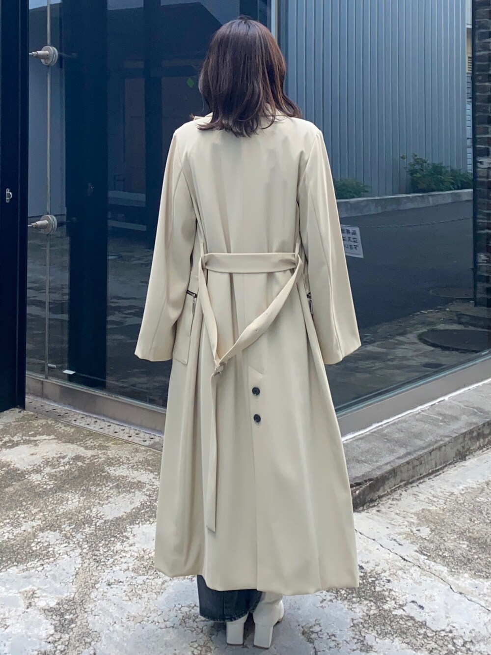 ベージュ系のトレンチコートを着用したレディースの冬コーディネートの3枚目の写真