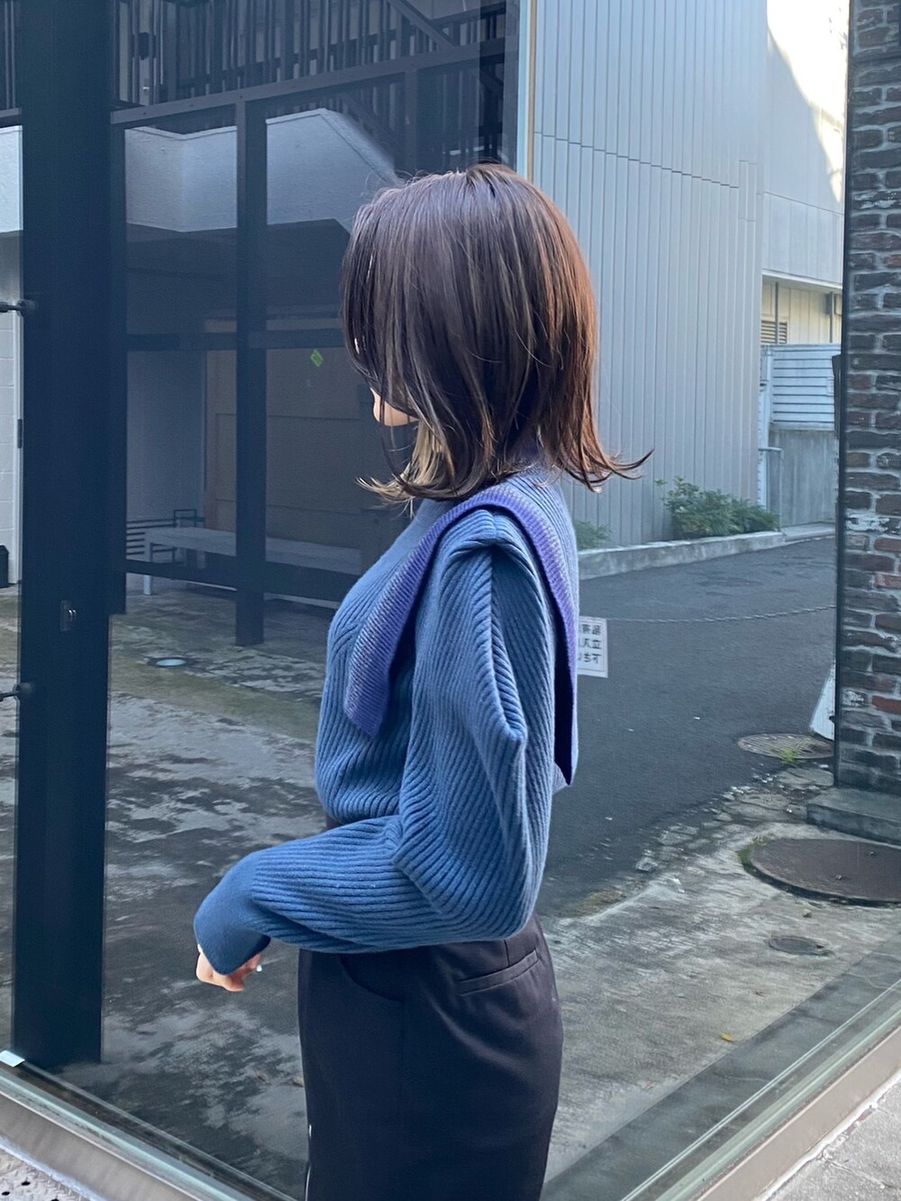 ブルー系のニット/セーター、ブラック系のその他パンツ、ブラック系のショルダーバッグを着用したレディースの冬コーディネートの7枚目の写真