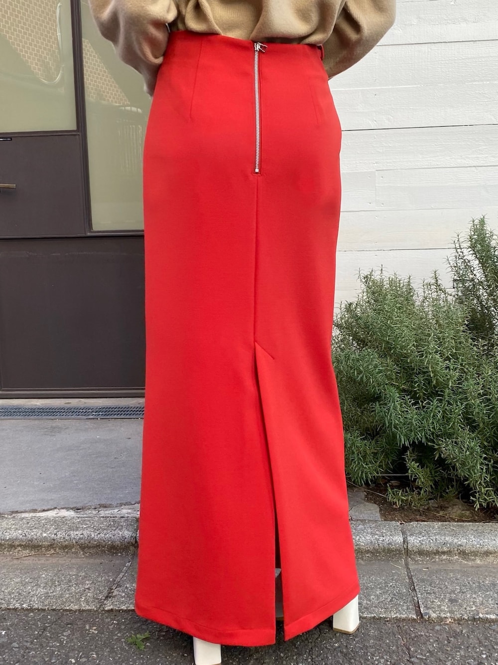 ベージュ系のニット/セーター、レッド系のスカート、シルバー系のショルダーバッグを着用したレディースの冬コーディネートの5枚目の写真