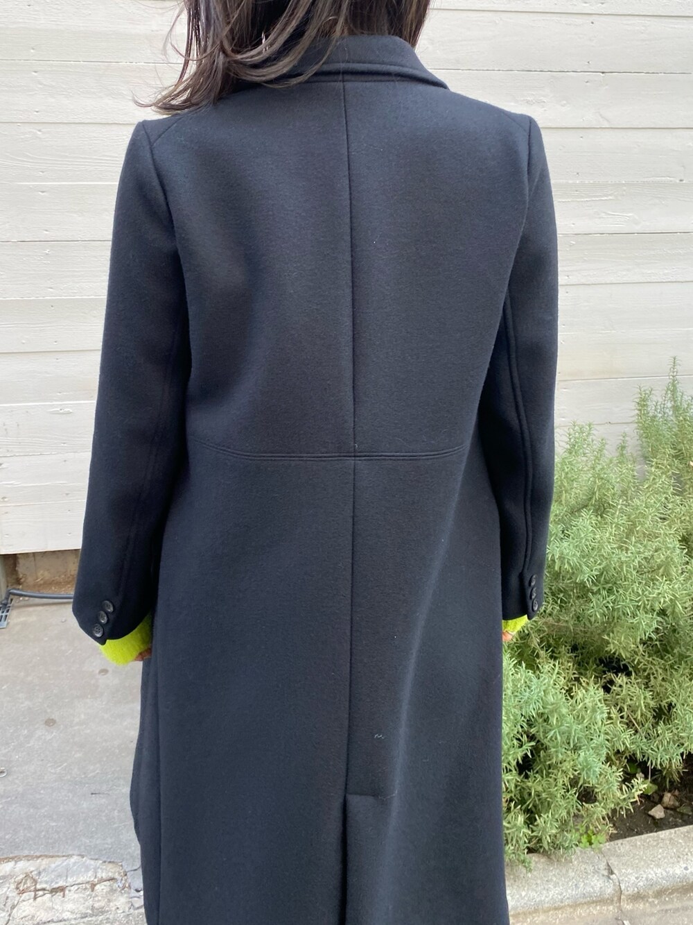 ブラック系のチェスターコートを着用したレディースの冬コーディネートの7枚目の写真