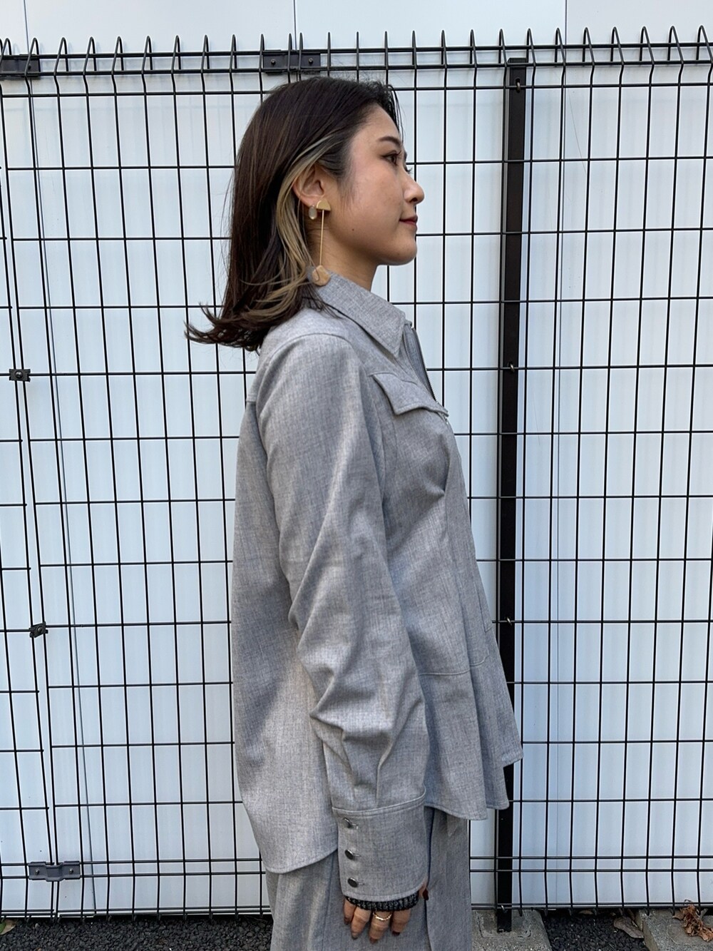 グレー系のシャツ/ブラウス、グレー系のスラックスを着用したレディースの冬コーディネートの6枚目の写真