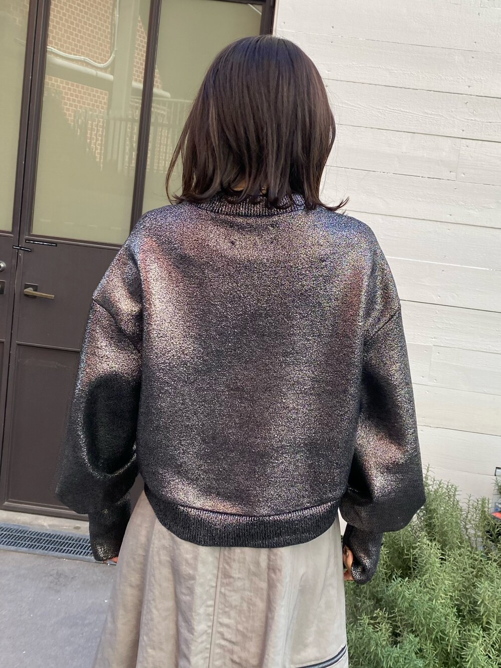 グレー系のスカート、シルバー系のニット/セーターを着用したレディースの冬コーディネートの7枚目の写真