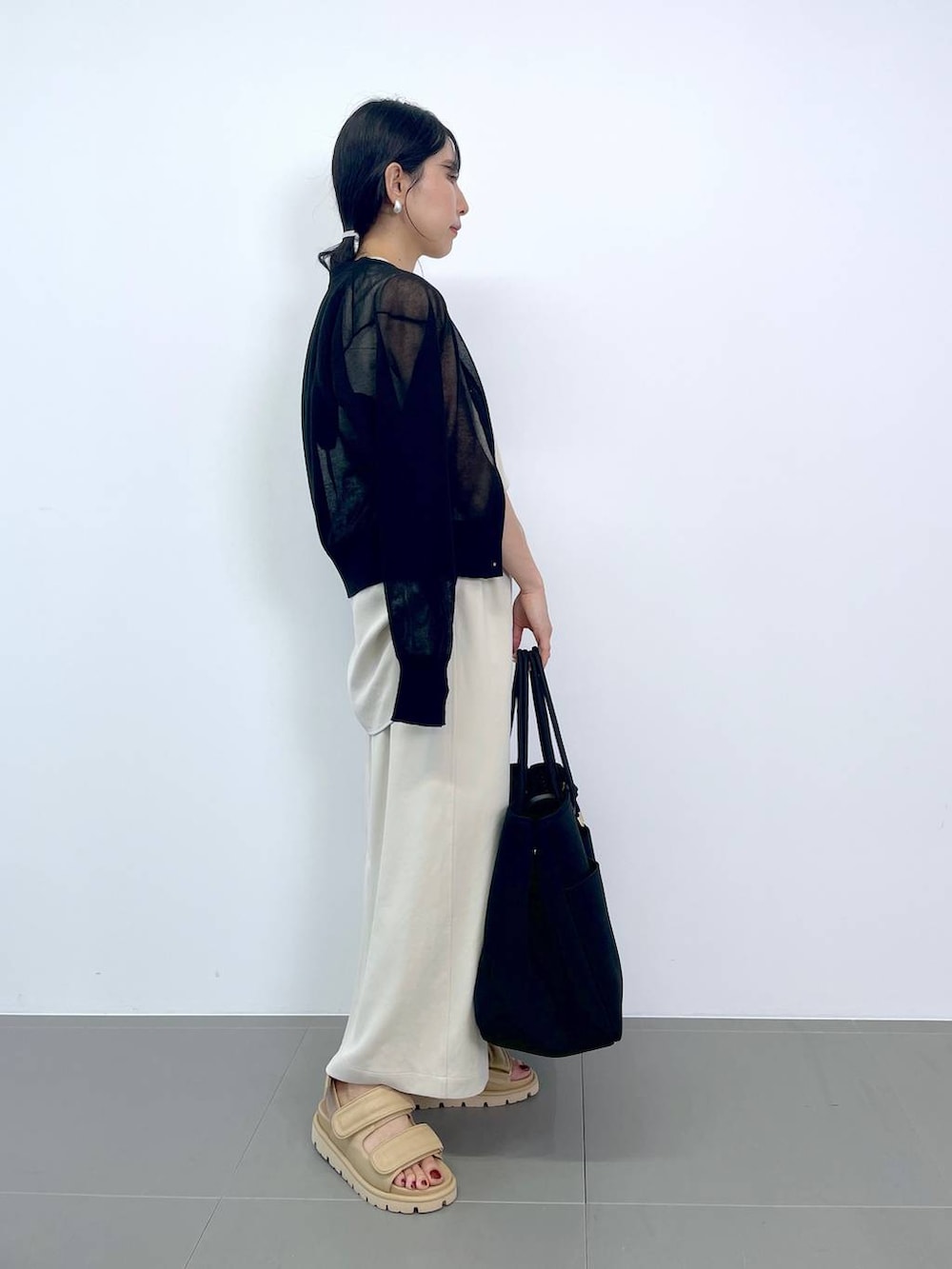 ホワイト系のTシャツ/カットソー、ホワイト系のスカート、ブラック系のトートバッグを着用したレディースの夏コーディネートの2枚目の写真