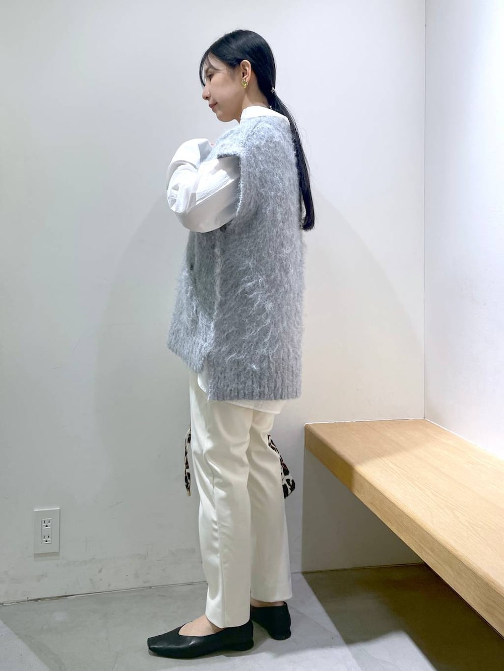 ブラック系のパンプス、ホワイト系のシャツ/ブラウス、その他のトートバッグを着用したレディースの冬コーディネートの2枚目の写真