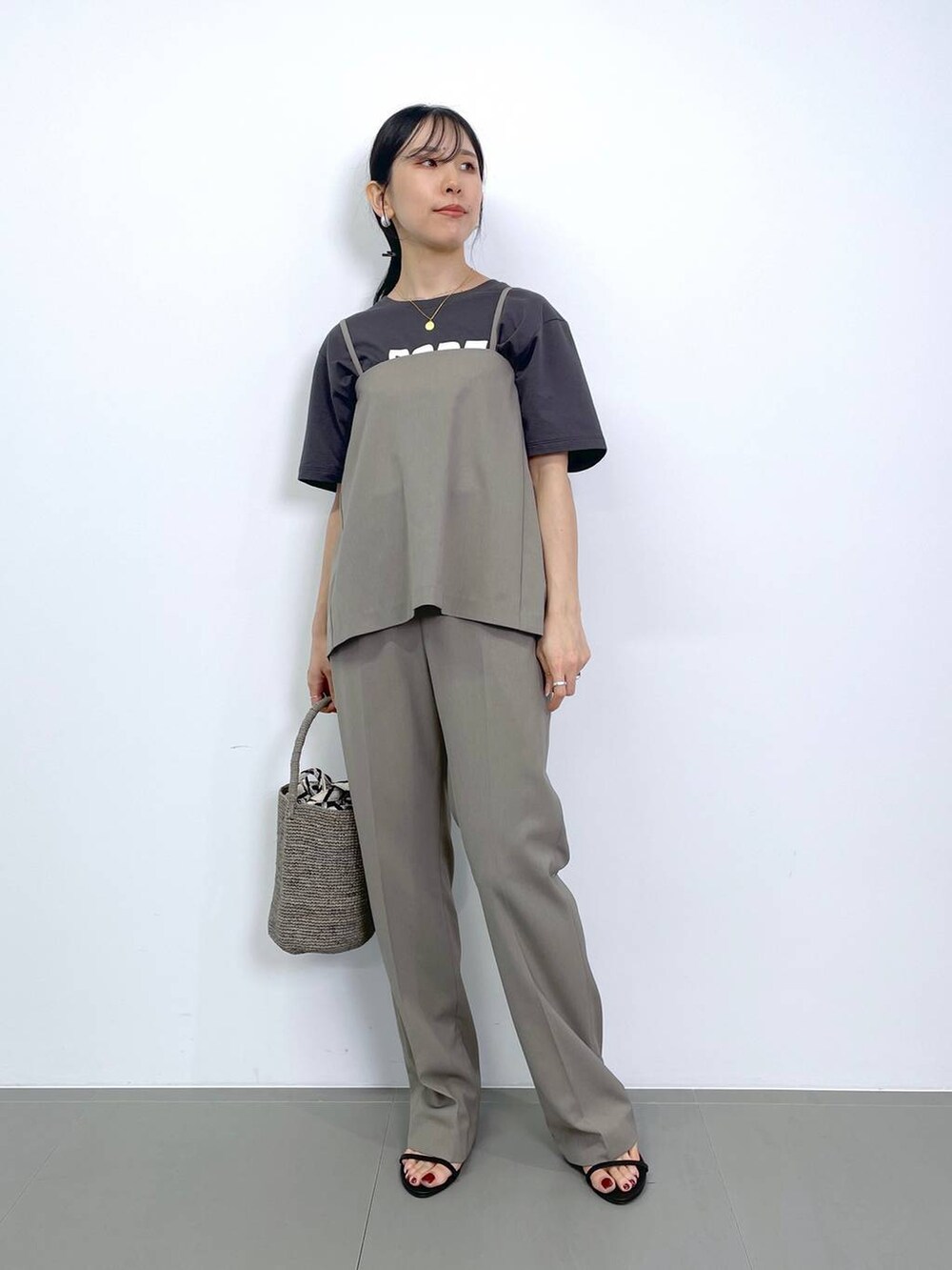 ブラック系のスリッポン、ホワイト系のトートバッグ、グレー系のトートバッグを着用したレディースの夏コーディネートの4枚目の写真