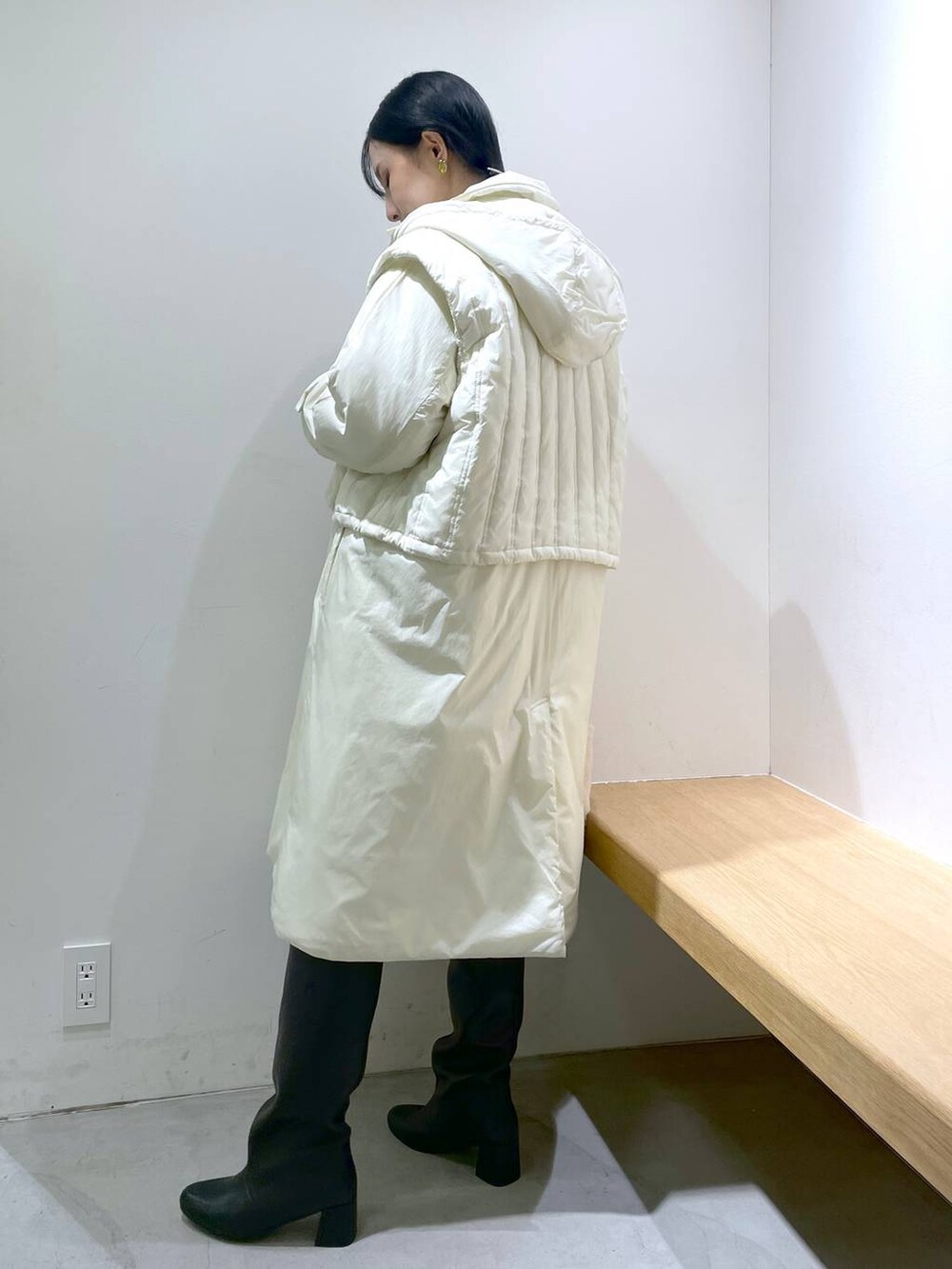 ブルー系のデニムパンツ、ブラック系のブーツ、ホワイト系のその他アウターを着用したレディースの冬コーディネートの3枚目の写真