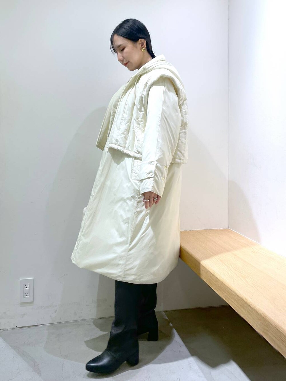 ブルー系のデニムパンツ、ブラック系のブーツ、ホワイト系のその他アウターを着用したレディースの冬コーディネートの2枚目の写真