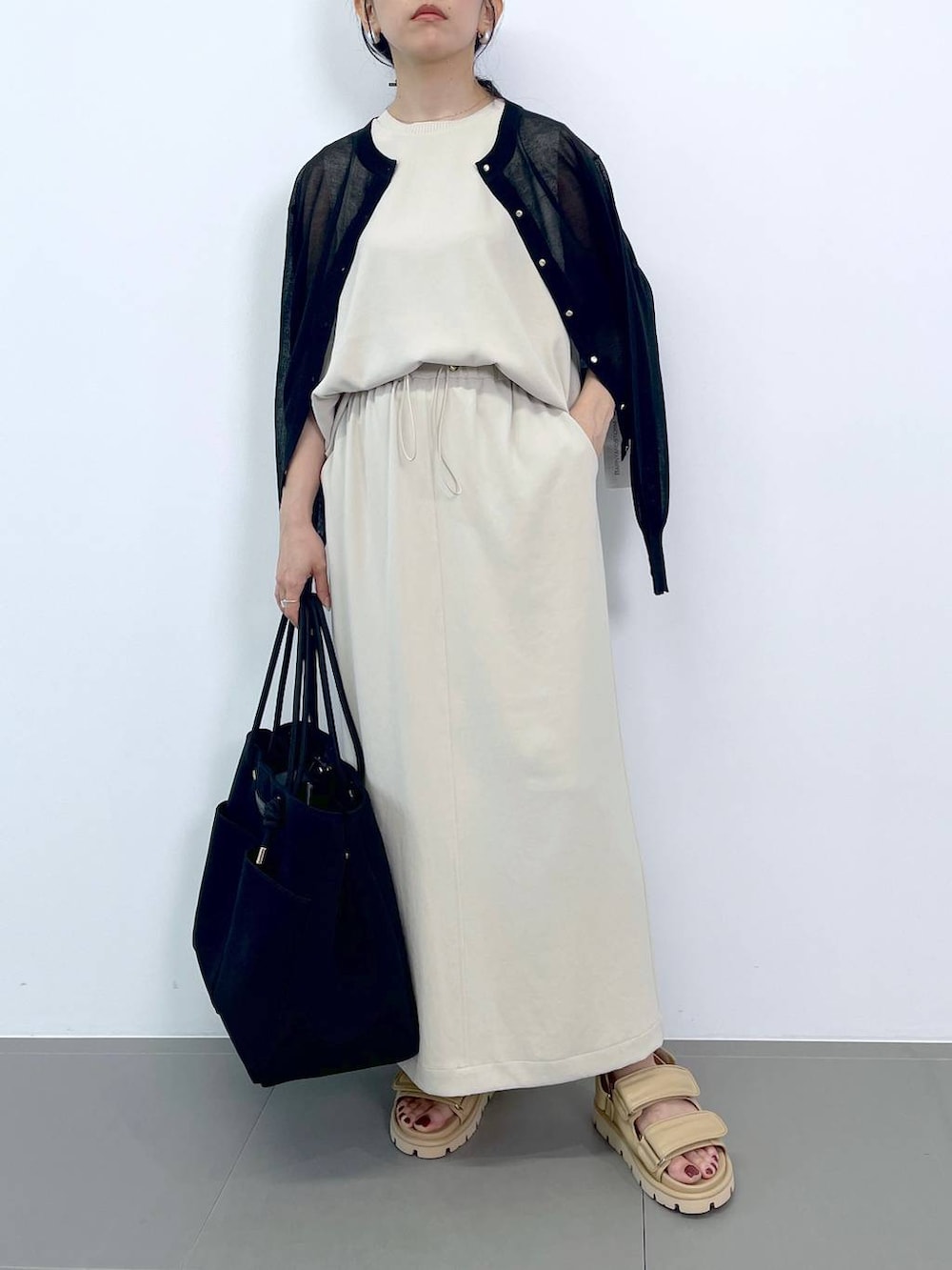 ホワイト系のTシャツ/カットソー、ホワイト系のスカート、ブラック系のトートバッグを着用したレディースの夏コーディネートの4枚目の写真