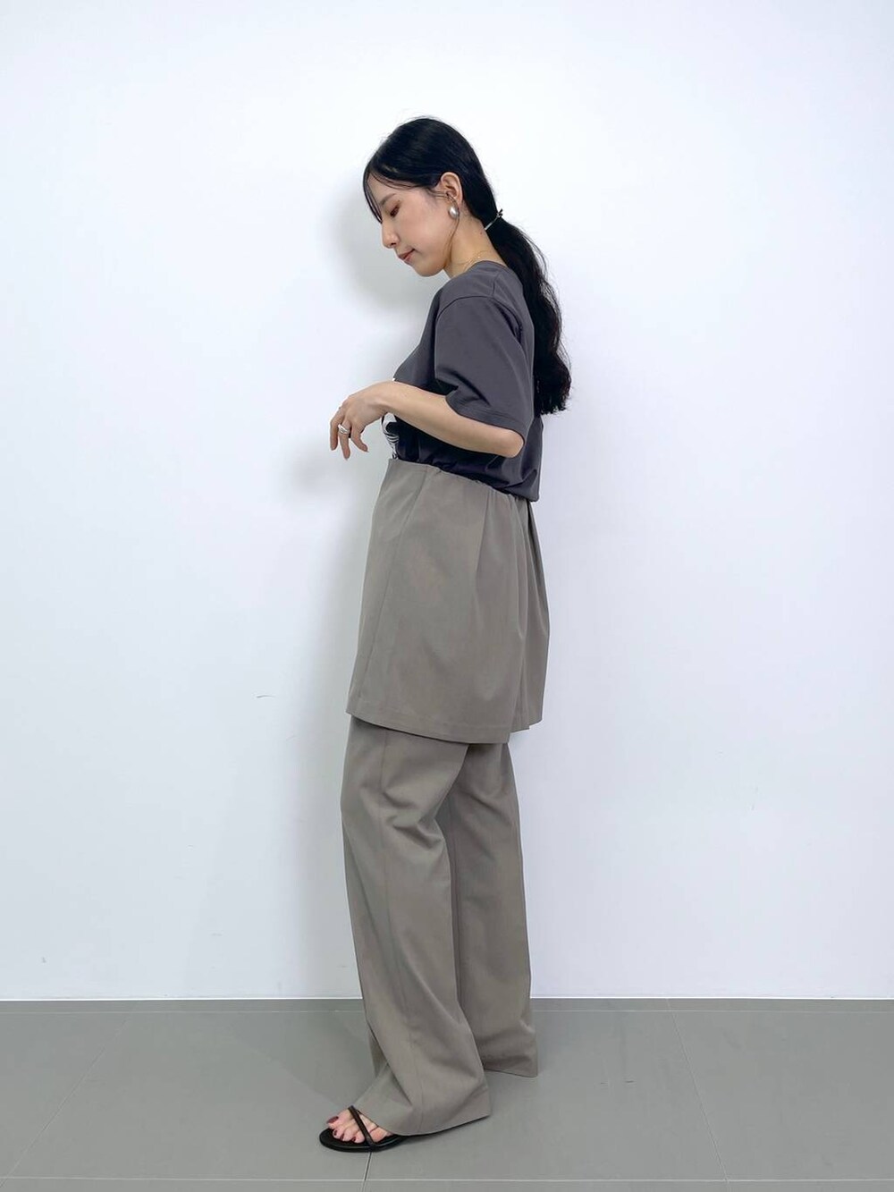 ブラック系のスリッポン、ホワイト系のトートバッグ、グレー系のトートバッグを着用したレディースの夏コーディネートの2枚目の写真