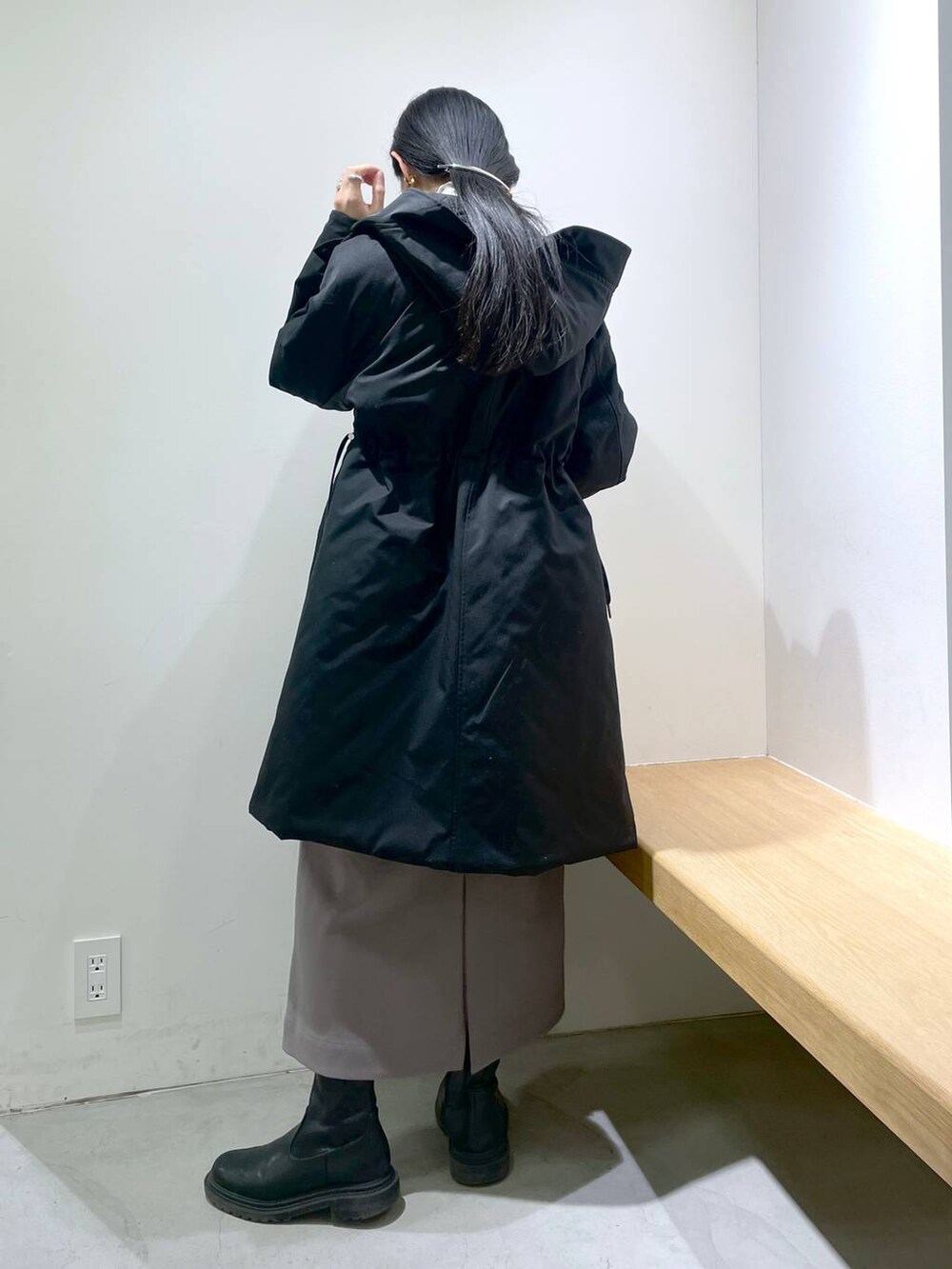 グレー系のワンピース、ブラック系のダウンジャケット/コート、ホワイト系のストール/ショールを着用したレディースの冬コーディネートの3枚目の写真