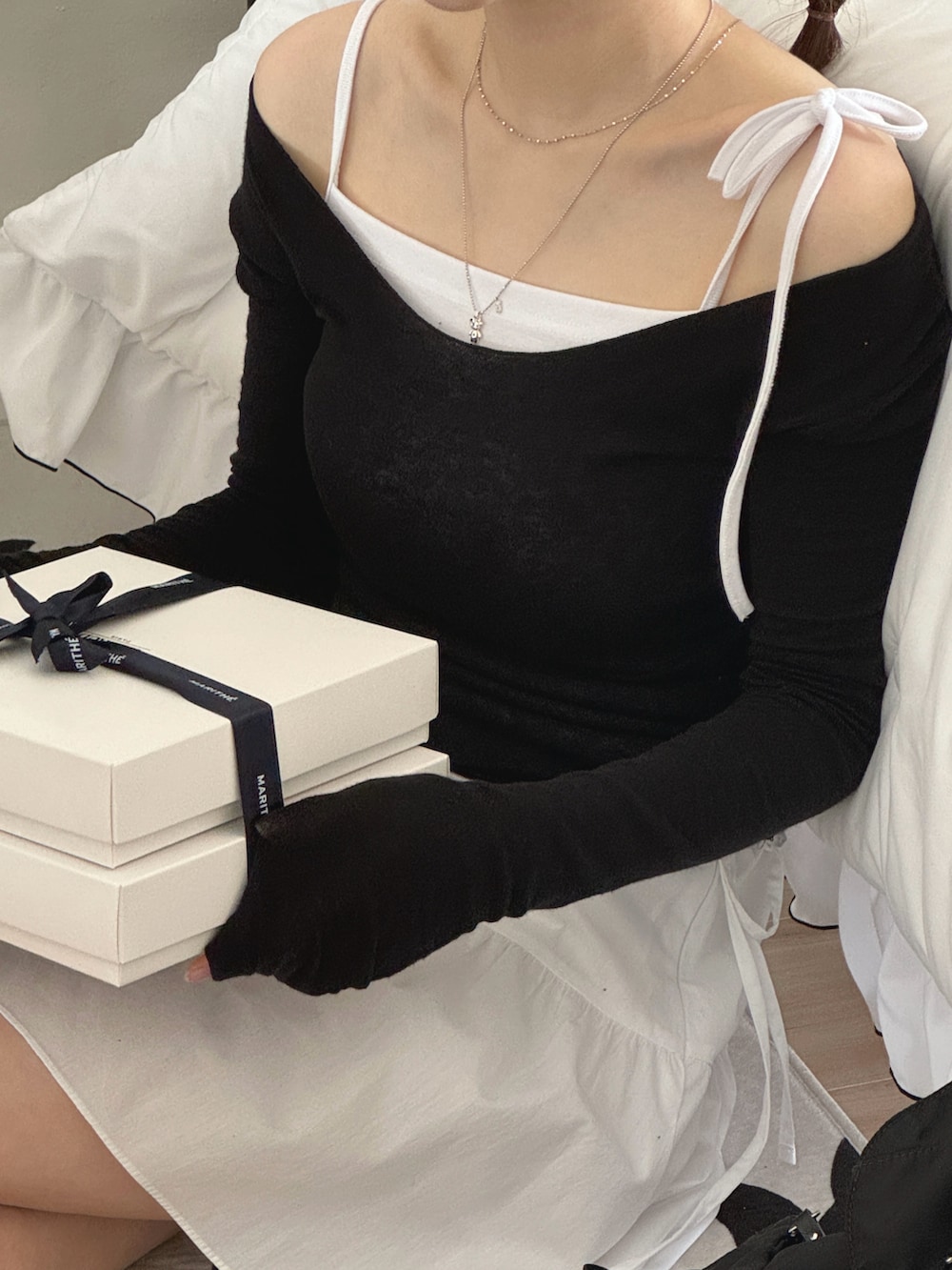 ブラック系のTシャツ/カットソー、ホワイト系のキャミソール、ホワイト系のスカートを着用したレディースの春コーディネートの2枚目の写真