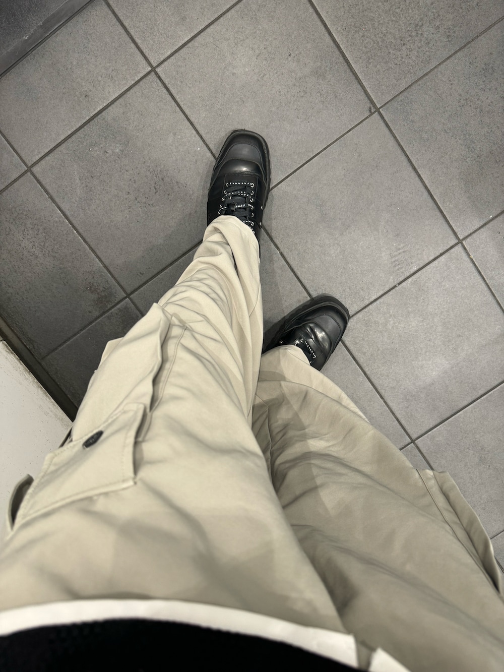 ブラック系のベスト、ホワイト系のシャツ/ブラウス、グレー系のカーゴパンツを着用したメンズの春コーディネートの2枚目の写真