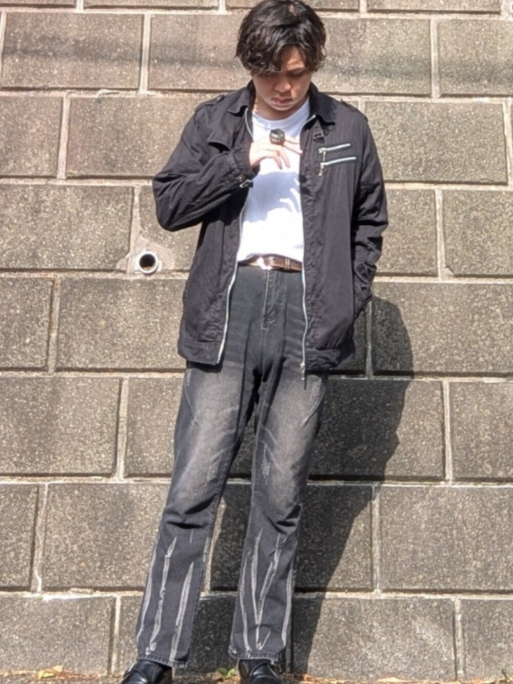 ブラック系のデニムパンツ、ブラック系のシューズ、ホワイト系のTシャツ/カットソーを着用したメンズの夏コーディネートの2枚目の写真