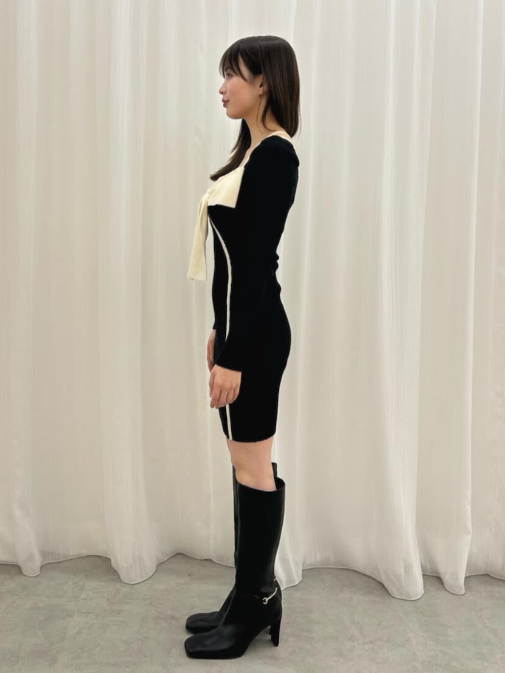 ブラック系のワンピース、ブラック系のブーツを着用したレディースの冬コーディネートの2枚目の写真