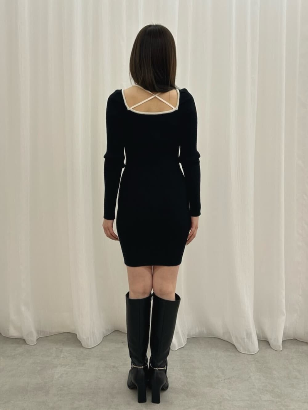 ブラック系のワンピース、ブラック系のブーツを着用したレディースの冬コーディネートの3枚目の写真