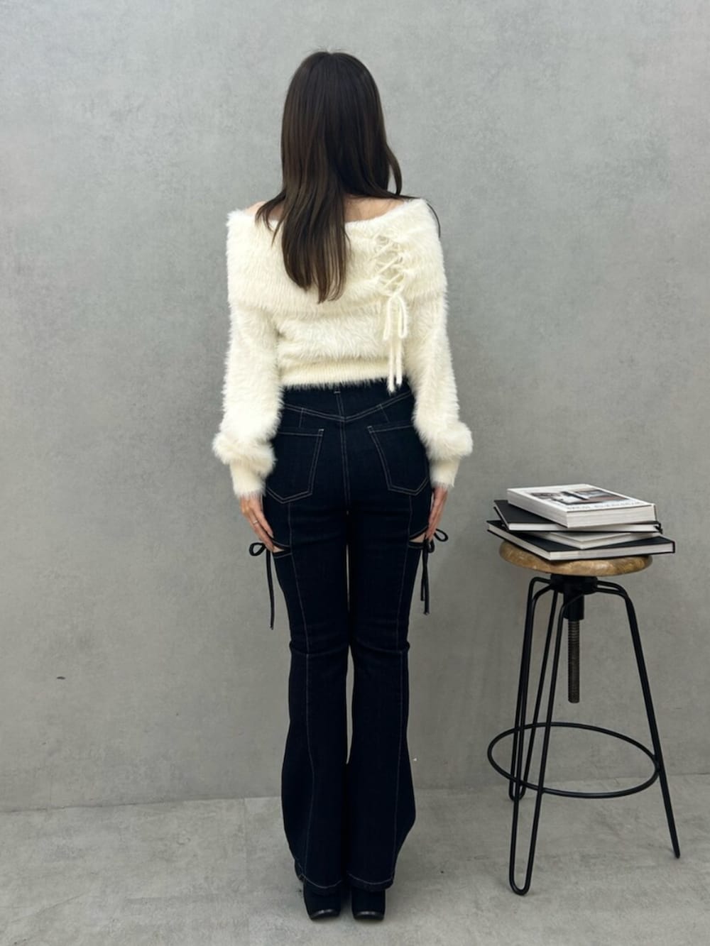 ブルー系のデニムパンツ、ホワイト系のニット/セーターを着用したレディースの秋コーディネートの3枚目の写真