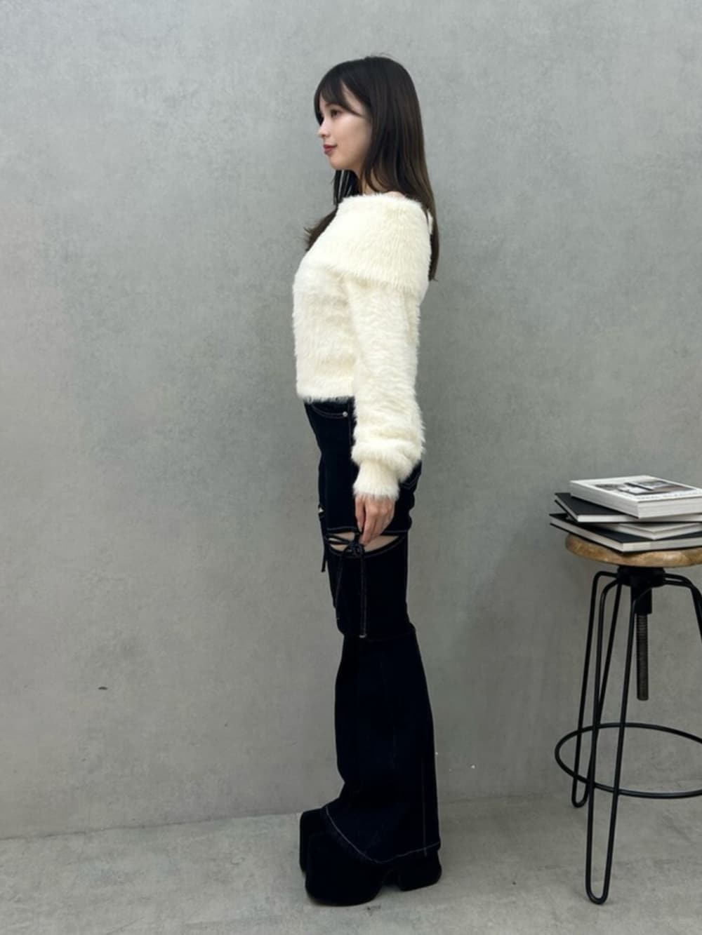 ブルー系のデニムパンツ、ホワイト系のニット/セーターを着用したレディースの秋コーディネートの2枚目の写真