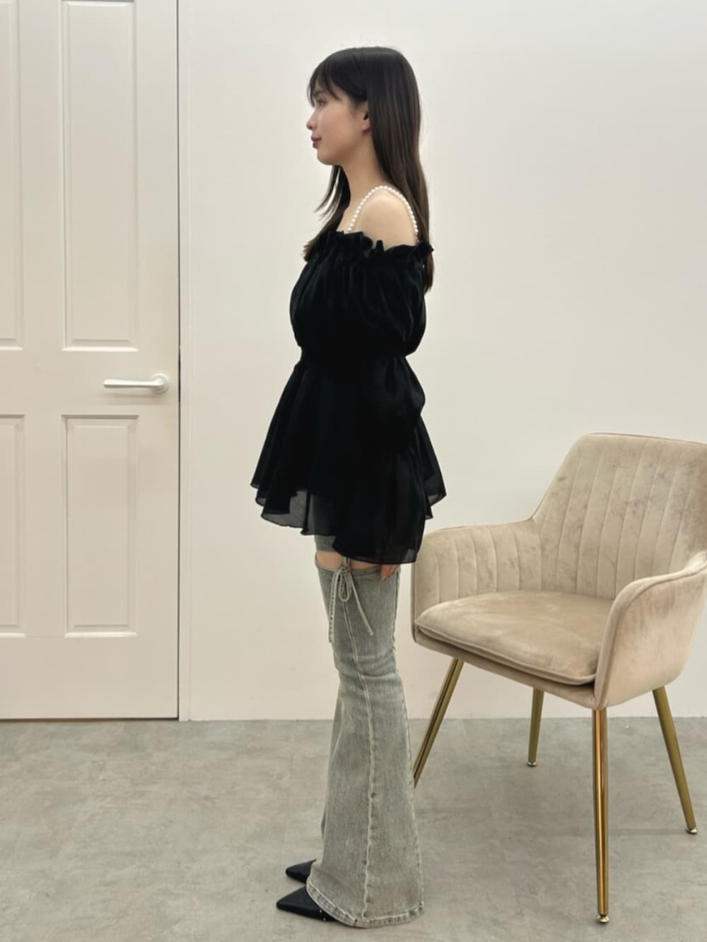 ブルー系のデニムパンツ、ブラック系のシャツ/ブラウス、ブラック系のパンプスを着用したレディースの冬コーディネートの2枚目の写真