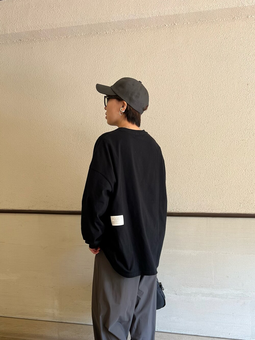 ブラック系のTシャツ/カットソー、ブラック系のスニーカーを着用したレディースの春コーディネートの5枚目の写真