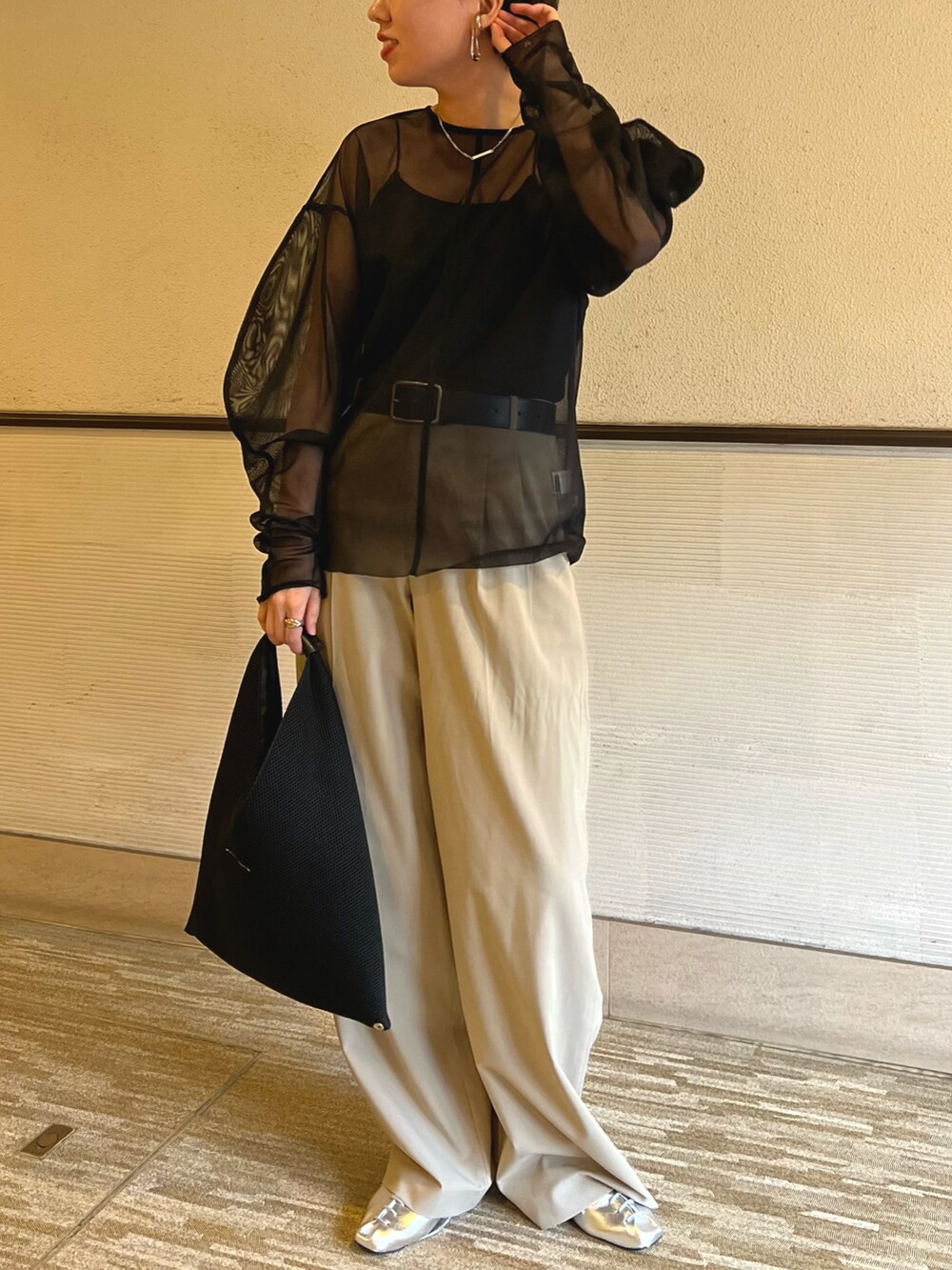 ブラック系のシャツ/ブラウス、ベージュ系のスラックス、ブラック系のハンドバッグを着用したレディースの春コーディネートの4枚目の写真