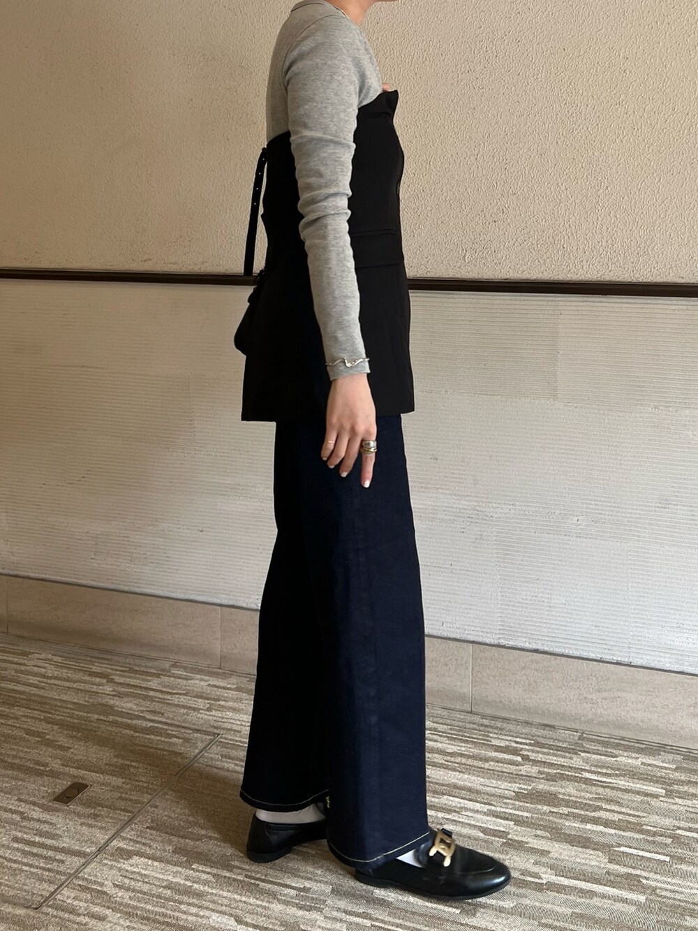 ブラック系のベスト、ブラック系のボストンバッグ、グレー系のTシャツ/カットソーを着用したレディースの春コーディネートの3枚目の写真