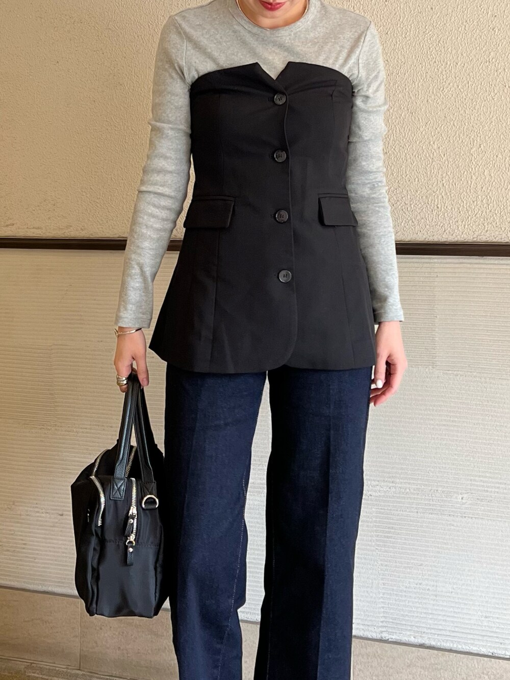 ブラック系のベスト、ブラック系のボストンバッグ、グレー系のTシャツ/カットソーを着用したレディースの春コーディネートの5枚目の写真