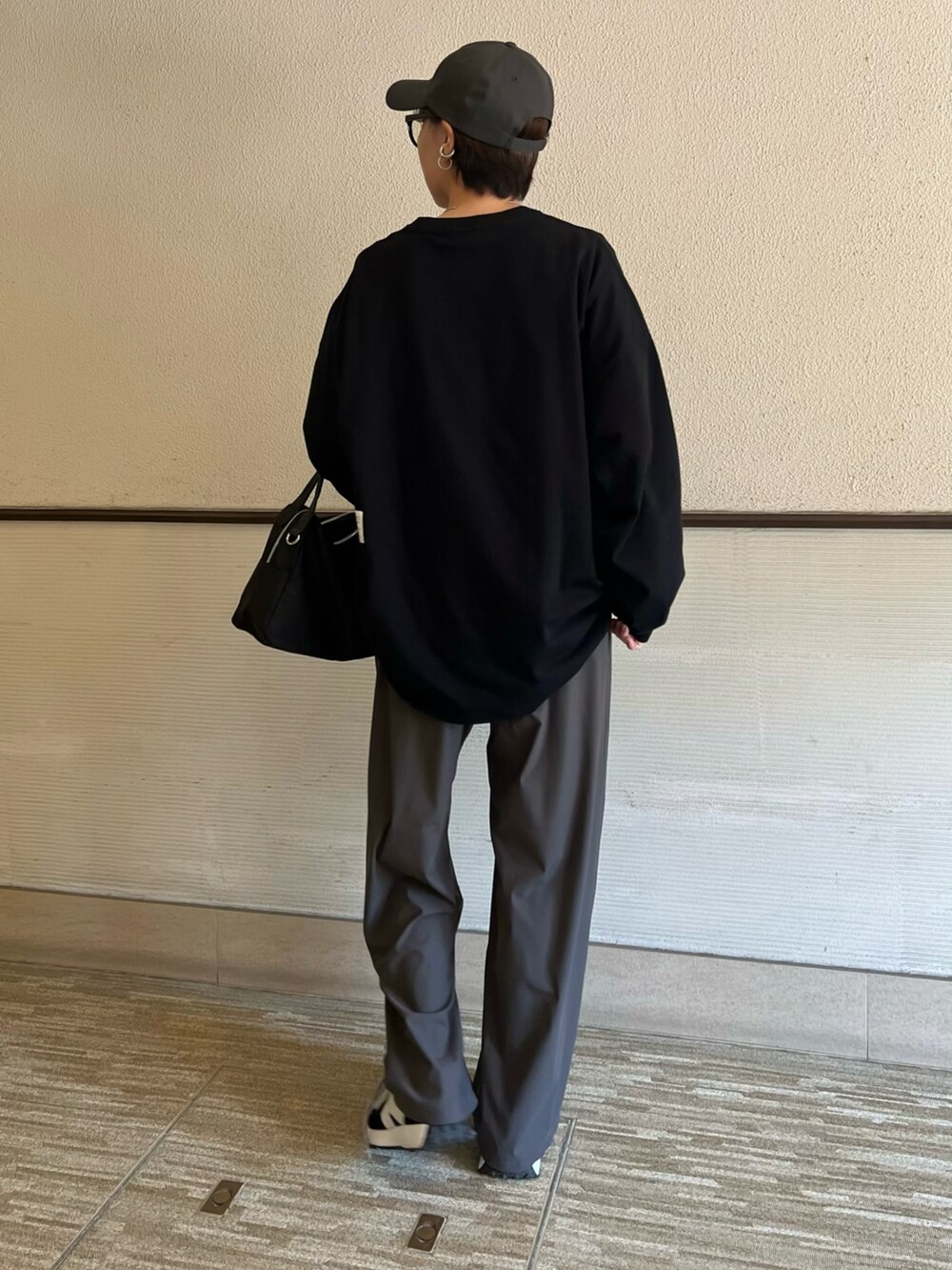 ブラック系のTシャツ/カットソー、ブラック系のスニーカーを着用したレディースの春コーディネートの4枚目の写真